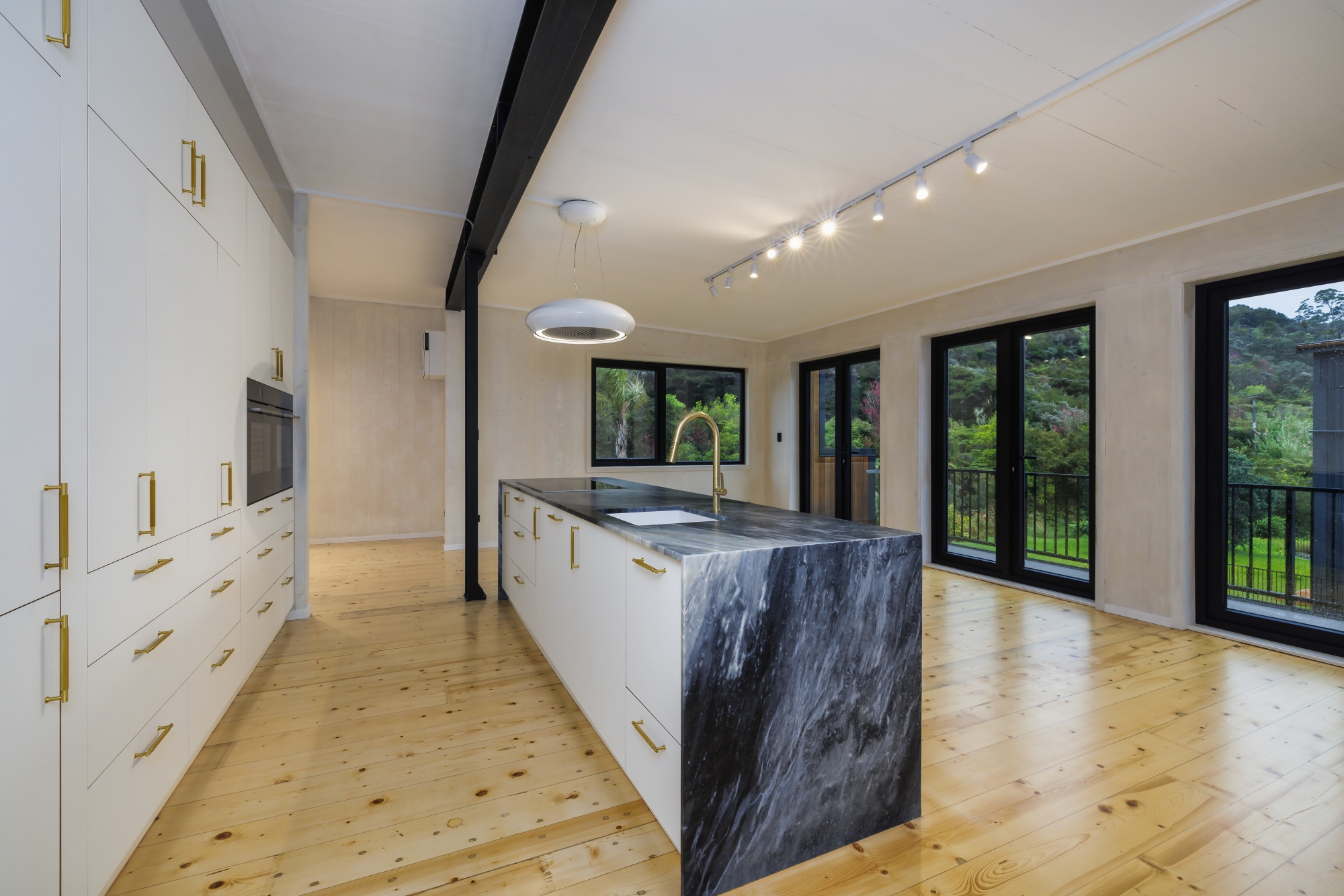 Completed timber home glowing at dusk in rural New Zealand