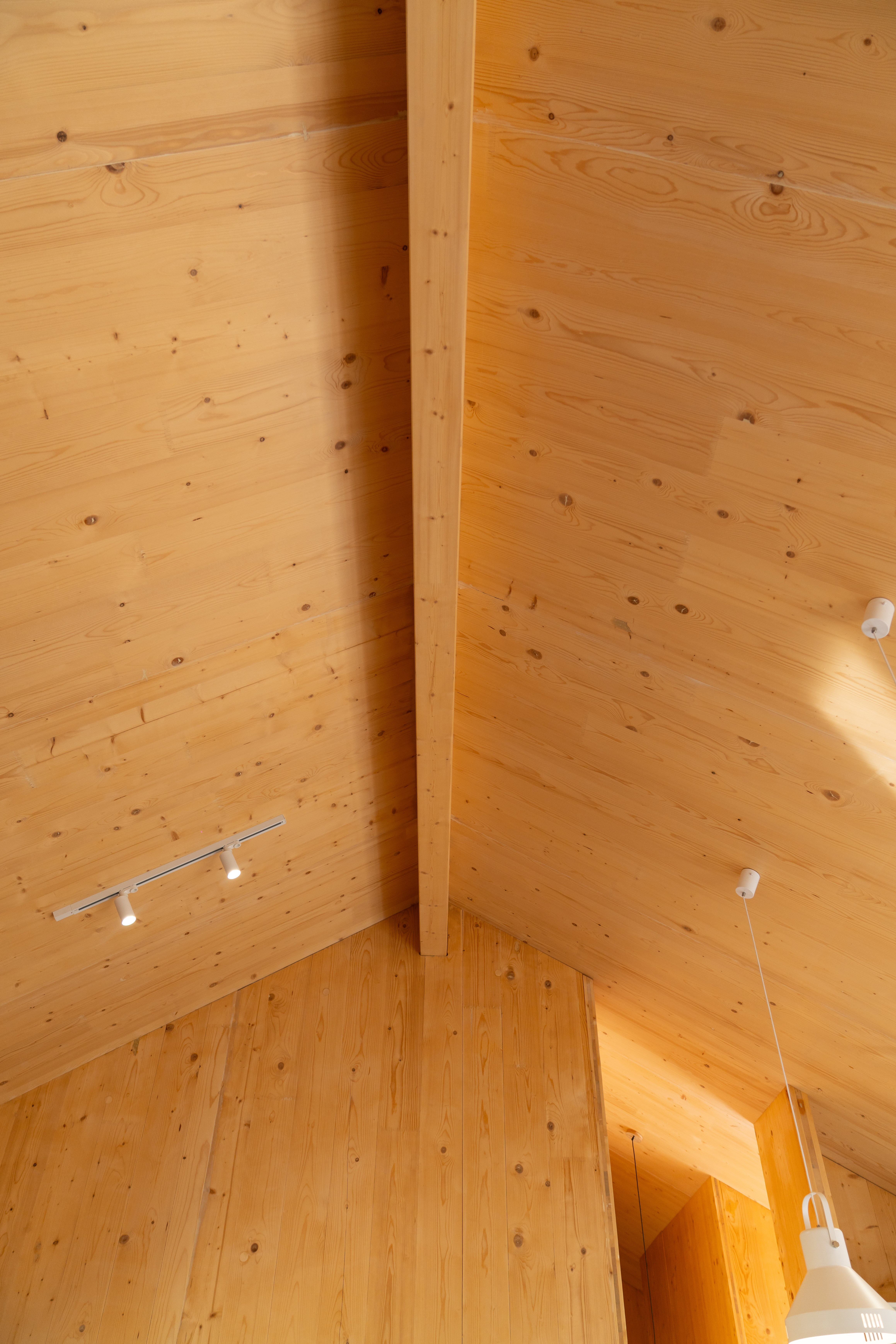Two-storey solid timber family home with gabled roof and wraparound deck